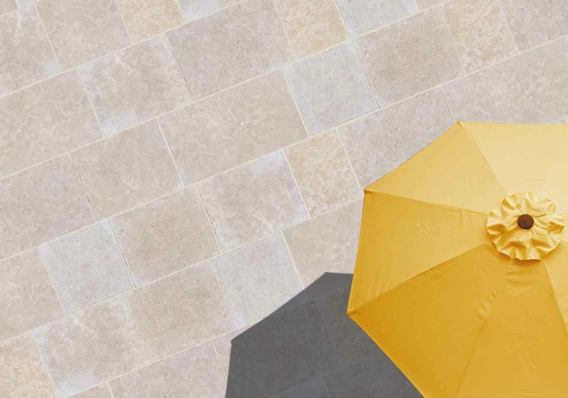 vue aérienne sur une terrasse conçue en dalles Khéops avec un parasol jaune