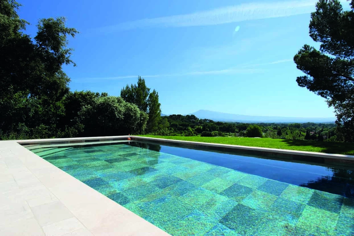 paysage ensoleillé d'une grande piscine et d'un beau ciel bleu dans un jardin