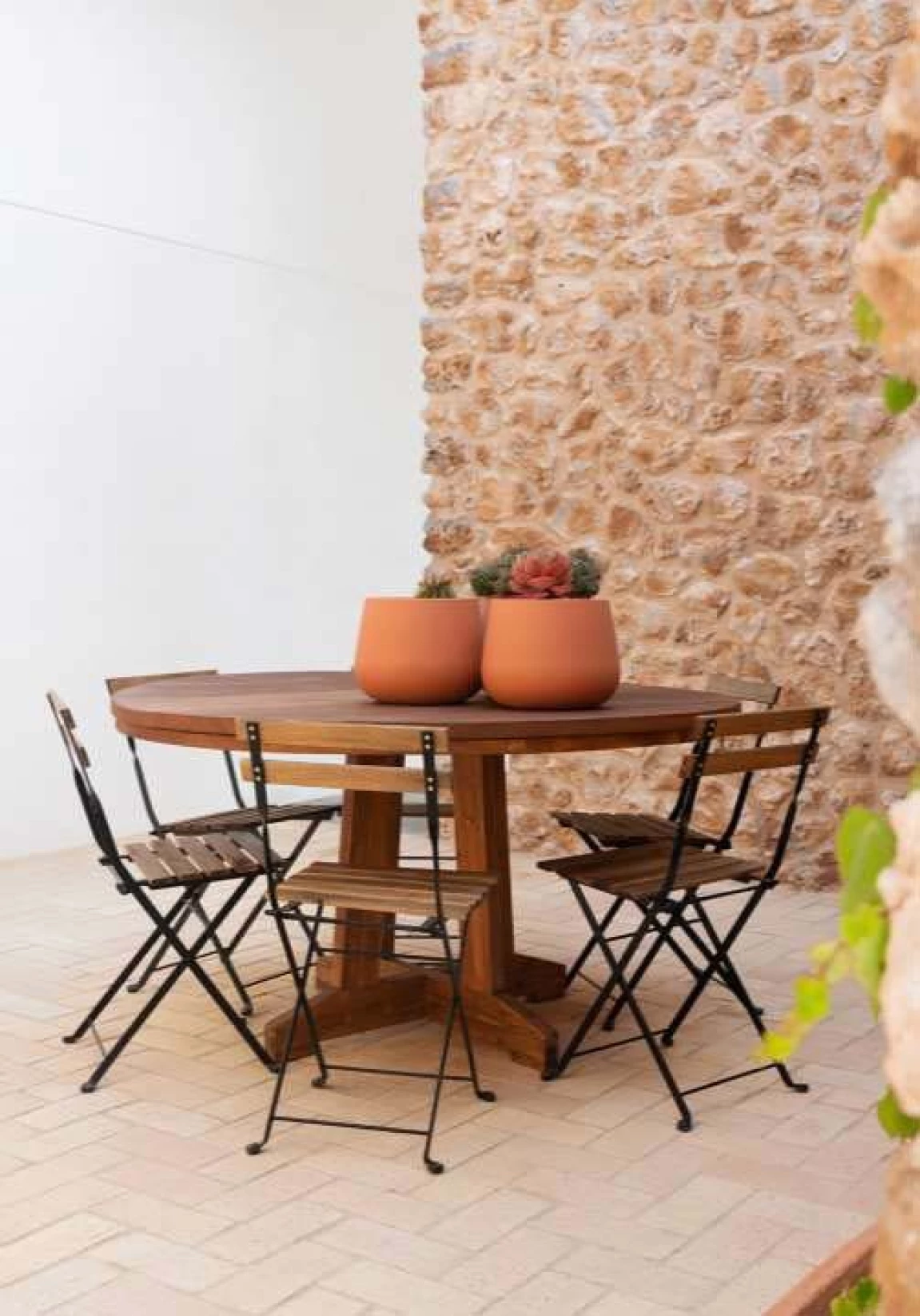photo d'une table d'extérieur, disposé devant un splendide mur en parement timanfaya meuliere