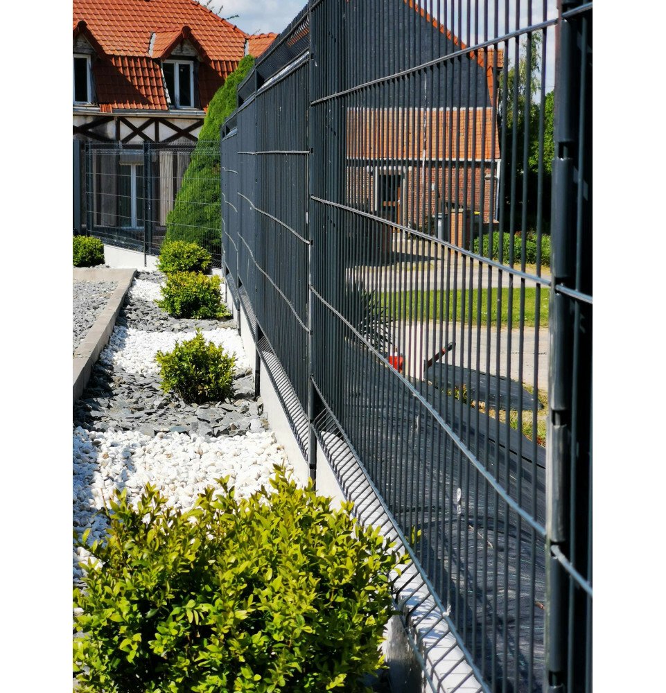 Grillage rigide gris avec soubassement séparant deux maisons